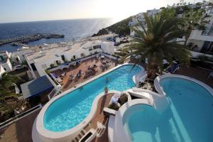 een uitzicht over het zwembad en de oceaan bij Modern & Spacious Studio Isla, Puerto Del Carmen in Tías