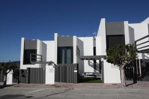 biały budynek z czarnymi oknami i drzewem w obiekcie Casa Melocotón - Designhouse mit privatem Pool, direkt am Golfplatz w mieście Caleta De Velez