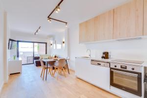 a kitchen and dining room with a table and chairs at AL - Apartamento Miratlântico in Quarteira