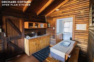 a kitchen with a table in a wooden cabin at JAYA'S PLACE in Hogsback