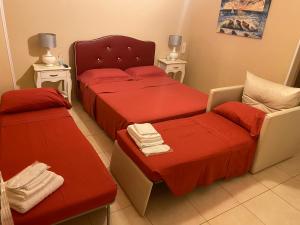 CarmianoにあるB&B Sud Estのベッドルーム1室(赤いシーツと椅子付きのベッド2台付)