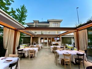 a patio with white tables and chairs and a building at Alla Passeggiata in Bussolengo