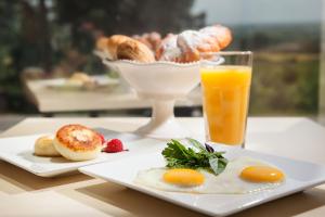 a plate of breakfast food and a glass of orange juice at Business Hotel Rodina in Essentuki