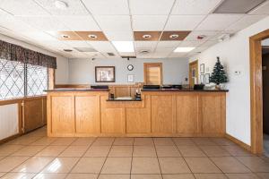 a waiting room with wooden cabinets and a counter in a building at OYO Hotel Windmill Branson in Branson
