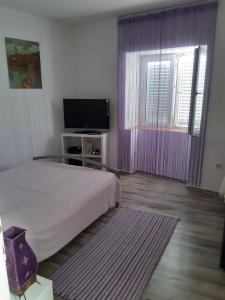 - une chambre avec un lit et une télévision à écran plat dans l'établissement Elena Mare, à Novi Vinodolski