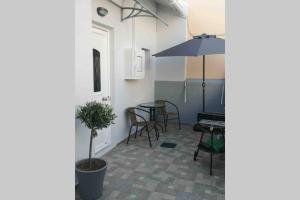 une terrasse avec une table et un parasol dans l'établissement CasaDiNova1, à Paradeísion