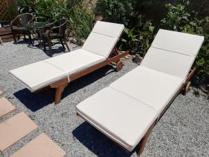 two white lounge chairs sitting on a patio at Wooden House at the Mountain-private in Paránimfoi