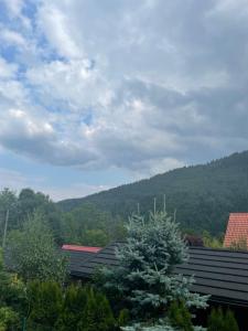 widok na dom z górą w tle w obiekcie Apartament Na Górce, sauna & jacuzzi w Szczyrku
