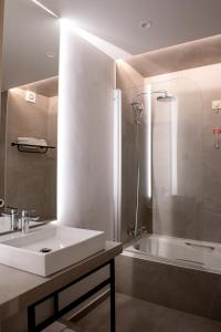 a bathroom with a sink and a bathtub at Hotel Cristal Setúbal in Setúbal