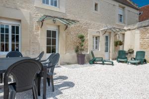 a patio with chairs and tables and a building at L'escalier rouge - Maison rénovée avec cour in Luc-sur-Mer