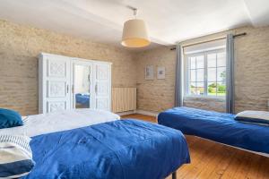 a bedroom with two beds and a window at L'escalier rouge - Maison rénovée avec cour in Luc-sur-Mer