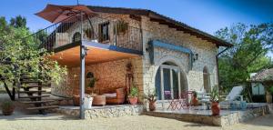 Casa de piedra pequeña con balcón y mesa en Villa Neli, Palazzolo Acreide, Siracusa, Hot Tub, Wi-Fi & Parking, en Palazzolo Acreide