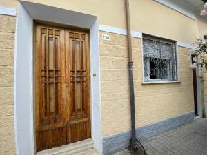 a building with a wooden door and a window at La casa del pescatore in Viareggio