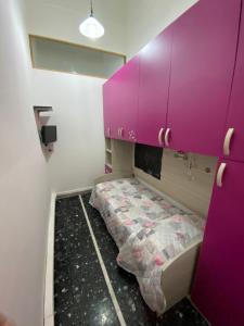 a room with a purple cabinet and a bed at La casa del pescatore in Viareggio