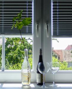 two bottles and two glasses on a window sill at Oase der Geborgenheit in Venningen