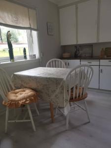 una cocina con mesa con 2 sillas y un pájaro en la ventana en Utleiebolig Fannrem, en Fannrem