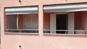 a pink building with two windows and a balcony at Molnar in Premantura