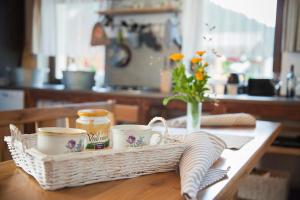 uma mesa com um cesto com copos e um vaso de flores em CHATAUDEDKA sk em Hrabušice