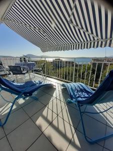 a couple of chairs and tables on a patio at Apartment Diana in Prvić Šepurine