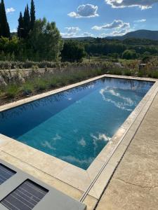 a swimming pool with blue water in a backyard at Les Palivettes 2.1 in Malaucène