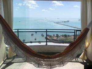 a hammock in a room with a view of the ocean at Flat Vista Completa Beira Mar in Fortaleza