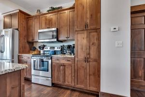 a kitchen with wooden cabinets and a stove top oven at Rockwood Lake Lodge home in Branson