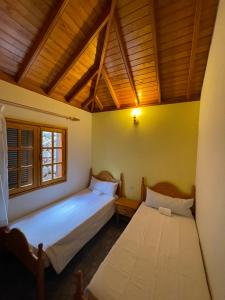 sypialnia z 2 łóżkami i drewnianym sufitem w obiekcie Villa Lomo Fragoso w mieście San Sebastián de la Gomera