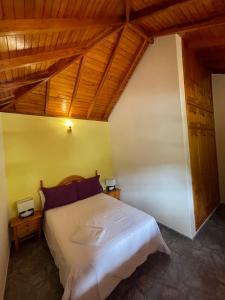 sypialnia z dużym białym łóżkiem i drewnianym sufitem w obiekcie Villa Lomo Fragoso w mieście San Sebastián de la Gomera