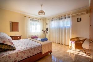 a bedroom with a bed and a chair at Paralia Platanou seaview house in Paralía Platánou