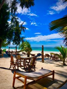 un grupo de mesas y sillas en una playa en Simba Beach Zanzibar, en Kiwengwa