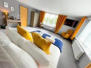 a living room with a white couch with yellow pillows at The Strutt Arms Hotel at The Elephant & Peacock in Belper