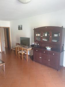 a living room with a table and a wooden cabinet at Condominio Flabelli in Baratti