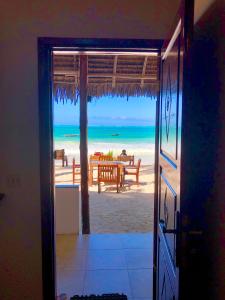 una puerta abierta con vistas a la playa en Simba Beach Zanzibar, en Kiwengwa