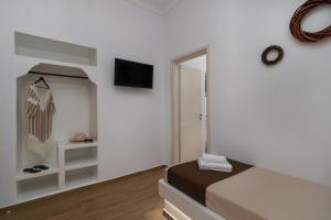1 dormitorio con 1 cama y TV en la pared en Holiday Home Triovasalos Milos, en Triovasálos