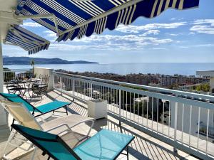 a balcony with chairs and tables and a view of the ocean at VUE DES ANGES AP4238 By Riviera Holiday Homes in Nice
