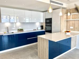 a kitchen with blue cabinets and a counter top at VUE DES ANGES AP4238 By Riviera Holiday Homes in Nice