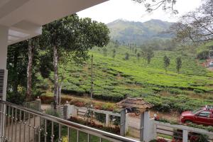 ムンナルにあるPeace Valley Home Stayの家のバルコニーから見た茶畑の眺め +3枚の写真