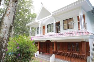 ムンナルにあるPeace Valley Home Stayの白い家(バルコニー付)