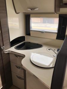 a small kitchen with a sink in a caravan at Prachtige mobilhome in Spanje te huur, staat klaar aan de luchthaven van Alicante in Alicante