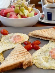 un plato con huevos y tostadas y un bol de fruta en Villa Athina, en Ambrami