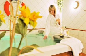 a woman standing in front of a sink with flowers in it at Skärgårdshotellet in Nynäshamn