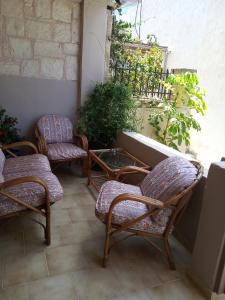 a group of chairs and a table on a patio at Buganvilla Sea View apts in Agia Pelagia