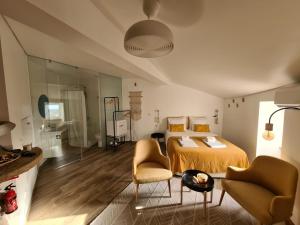 a bedroom with a bed and two chairs at On The Rocks in Monsanto