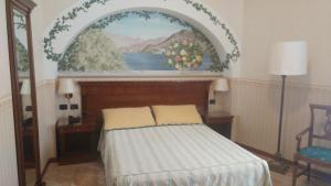 1 dormitorio con 1 cama y una pintura en la pared en Hotel Posta, en Moltrasio