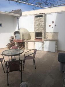 a patio with a table and chairs and a pizza oven at Casa Bella-suit in Ciudadela Costa de Oro