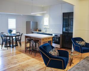 eine Küche mit einem Tisch und Stühlen sowie einem Tisch und Stühlen in der Unterkunft Alexander Cottage Daylesford in Daylesford
