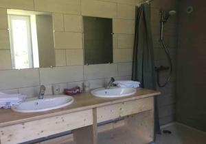 uma casa de banho com 2 lavatórios e um espelho grande em Dormez dans la chambre du meunier ! em Germolles-sur-Grosne