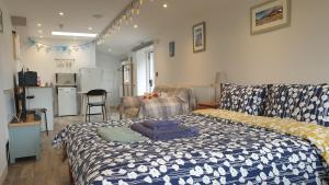 um quarto com uma cama com um cobertor azul e branco em The Nook B&B em Port Isaac