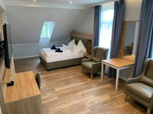 a bedroom with a bed and two chairs and a table at Stayhome Tossens in Butjadingen