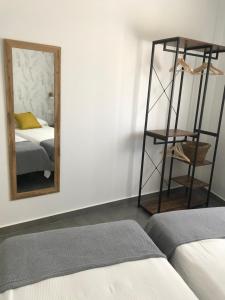 Dormitorio con espejo, cama y estante en Apartamentos Ad Theatrum, en Mérida
